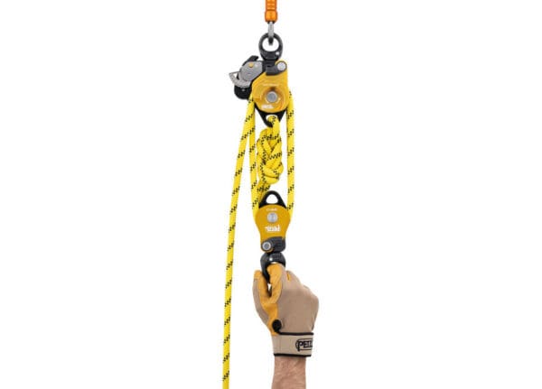 Hand holding a yellow rope pulley.