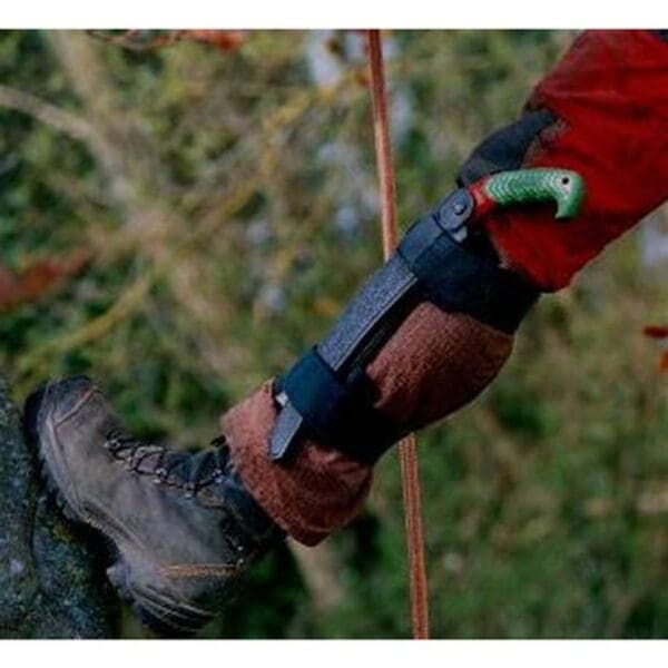 A person climbing a tree with a saw.